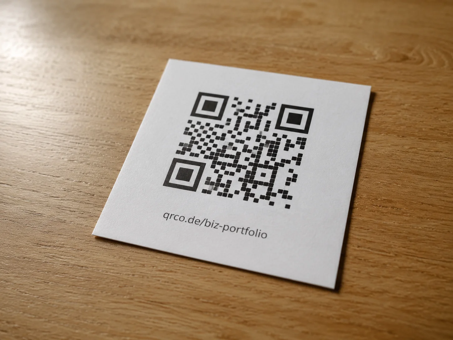 Printed menu card on a wooden table showing a QR code with a short URL printed below it, demonstrating the accessible physical print pattern